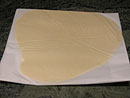 latten the dough between two pieces of parchment paper 