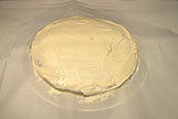 Cut a circle in a piece of parchment paper that is slightly smaller than the cake round and set ove the cake
