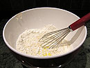 Add the milk, water, vinegar and beaten egg to the flour and stir until the dry and liquid ingredients are incorporated