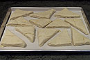 Cut each half into 4 triangles and place on a parchment lined baking sheet